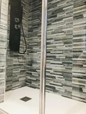 a shower in a bathroom with a stone wall at lucushouse III in Lugo