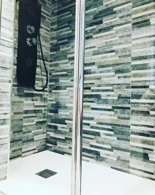 a bathroom with a shower with a stone wall at lucushouse III in Lugo