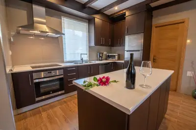a kitchen with a counter with a bottle of wine and glasses at Casa Visita Ribeira Sacra in Chantada