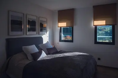 a bedroom with a bed and two windows at Beche EcoCamp in Santa Eulalia