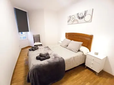 a bedroom with a bed and a chair in it at Viveiro Muralla in Viveiro
