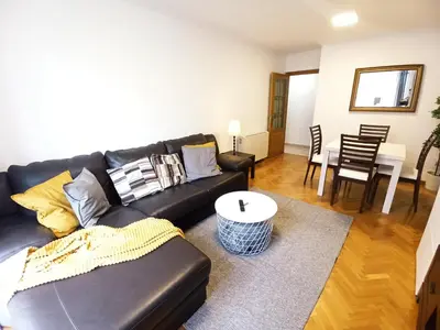 a living room with a black leather couch and a table at Viveiro Muralla in Viveiro