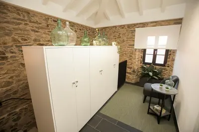 a white cabinet with green glass bottles on top at ALBERGUE O FERVELLO in Santiago de Compostela