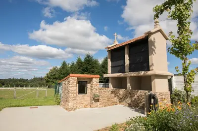 a small stone chapel with a cross on top of it at ALBERGUE O FERVELLO in Santiago de Compostela