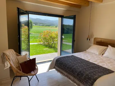 a bedroom with a bed and a sliding glass door at Grandes Duplex nuevos con Jardin y Barbacoa - 3 llaves, Los Gayoles Rural in Castropol