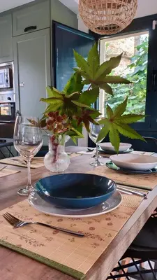 a wooden table with a blue plate and glasses on it at Grandes Duplex nuevos con Jardin y Barbacoa - 3 llaves, Los Gayoles Rural in Castropol