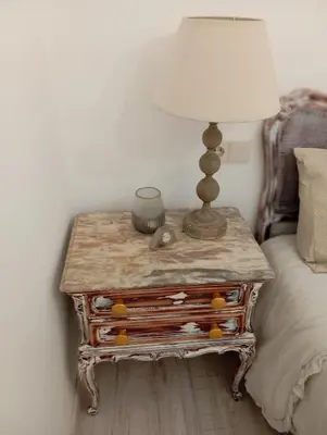 a table with a lamp on it next to a bed at Piso Iwvaxi, gallery house. Ourense. in Ourense