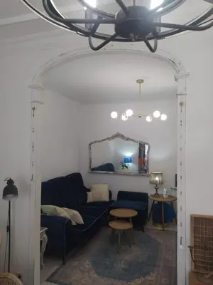 a living room with a blue couch and a mirror at Piso Iwvaxi, gallery house. Ourense. in Ourense