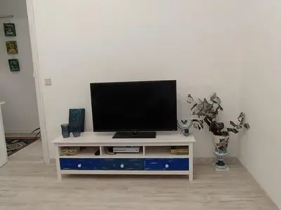 a flat screen tv sitting on a white entertainment center at Piso Iwvaxi, gallery house. Ourense. in Ourense