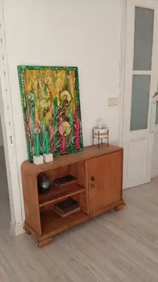 a painting sitting on top of a wooden cabinet at Piso Iwvaxi, gallery house. Ourense. in Ourense