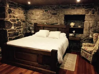a bedroom with a bed and a stone wall at Casa o Cantón in Berredo