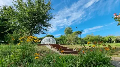 a greenhouse in the middle of a field with flowers at Finca Bouzas in Teo