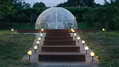 a glass dome with stairs in a field with lights at Finca Bouzas in Teo
