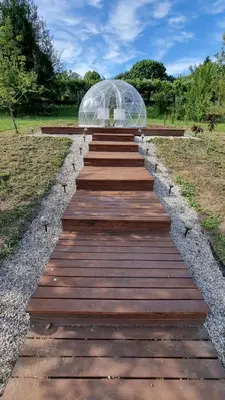 a wooden walkway leading to a glass greenhouse at Finca Bouzas in Teo