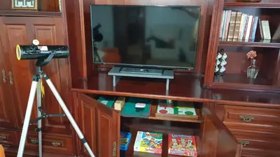 a television on a wooden entertainment center with a camera at Finca Bouzas in Teo