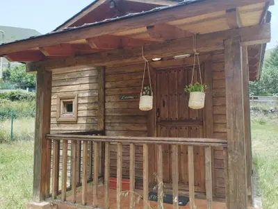 a wooden dog house with two baskets on it at CAMPING LA ZARAPICA - Palacios del Sil in Palacios del Sil