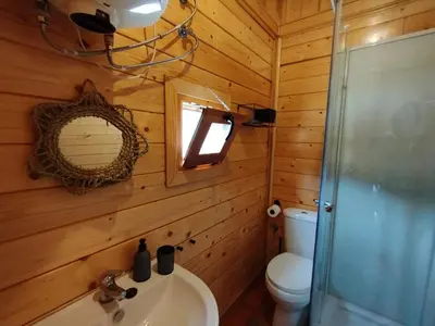 a bathroom with a toilet and a sink and a mirror at CAMPING LA ZARAPICA - Palacios del Sil in Palacios del Sil