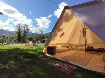 a large tent with a bed in the grass at CAMPING LA ZARAPICA - Palacios del Sil in Palacios del Sil
