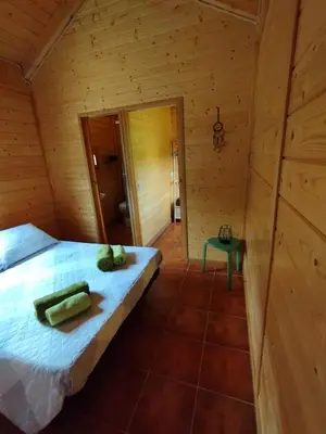 a bedroom with a bed in a wooden room at CAMPING LA ZARAPICA - Palacios del Sil in Palacios del Sil