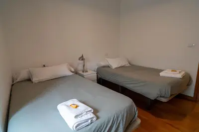a room with two beds with towels on them at APARTAMENTOS SARMIENTO in Mondoñedo