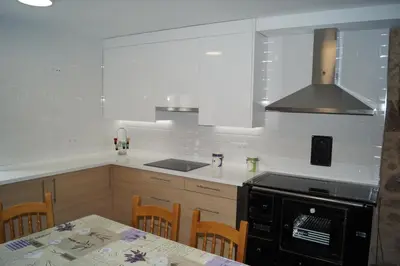 a kitchen with a stove and a table with chairs at Casa Marisa in Teo