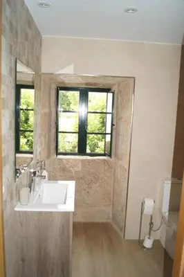 a bathroom with a sink and a window and a toilet at Casa Marisa in Teo