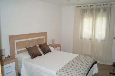 a bedroom with a bed with white sheets and a window at Casa Marisa in Teo