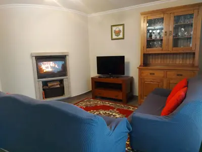 a living room with a blue couch and a television at Casa Marisa in Teo