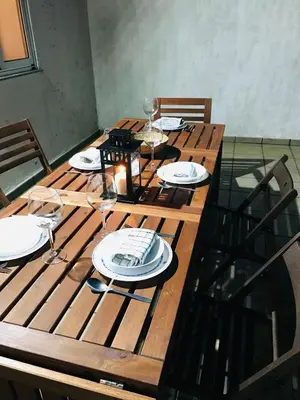 a wooden table with plates and wine glasses on it at Casa CHORIMA in Arzúa