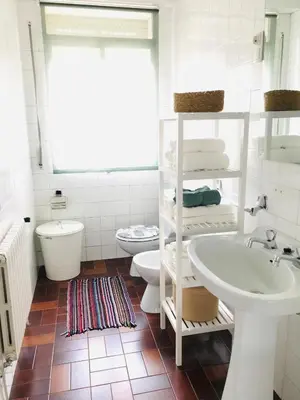 a white bathroom with a sink and a toilet at Casa CHORIMA in Arzúa