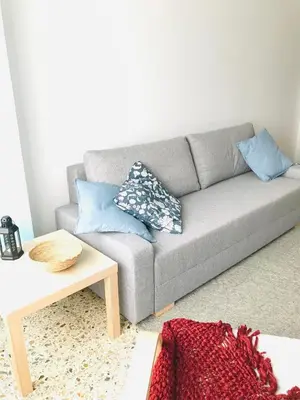 a living room with a gray couch with blue pillows at Casa CHORIMA in Arzúa