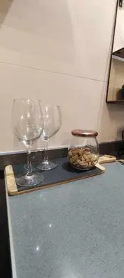 three wine glasses and a bowl of nuts on a counter at Precioso Apartamento 1 Hab con Bañera Hidromasaje in O Barco de Valdeorras