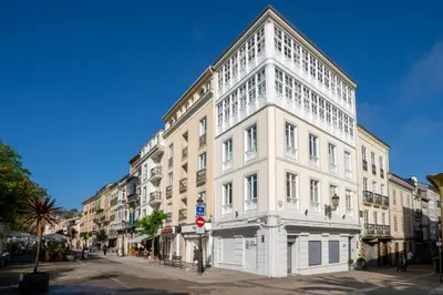 a large white building on the corner of a street at Apartamentos Turísticos Casa Arango in Ribadeo