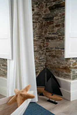 a room with a stone wall and two starfish at Apartamentos Turísticos Casa Arango in Ribadeo