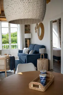 a living room with a blue couch and a table at Apartamentos Turísticos Casa Arango in Ribadeo