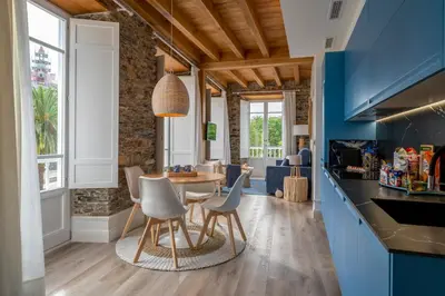 a kitchen and dining room with a table and chairs at Apartamentos Turísticos Casa Arango in Ribadeo