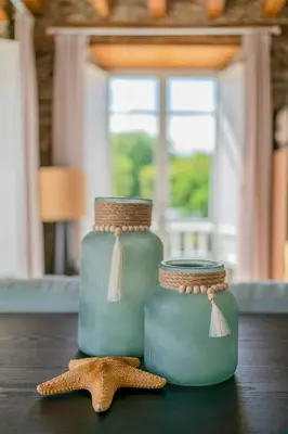 two green jars sitting on a table with a starfish at Apartamentos Turísticos Casa Arango in Ribadeo