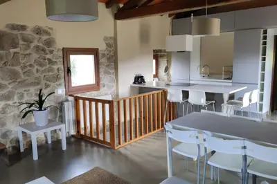 a kitchen with a table and chairs in a room at Casa Rural Elvira Ribeira Sacra in Asma