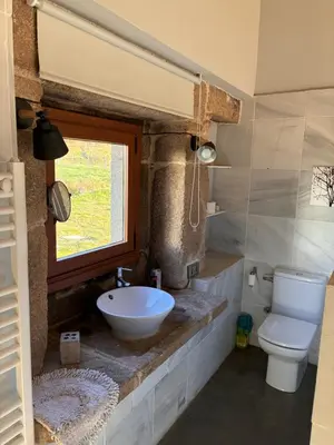 a bathroom with a sink and a toilet and a window at Casa Rural Elvira Ribeira Sacra in Asma