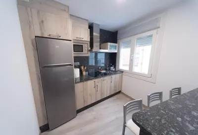 a kitchen with a refrigerator and a table with chairs at Apartamento TerradeAugas3 in Caldas de Reis