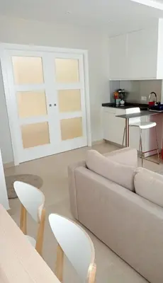 a living room with a couch and a table and chairs at Apartamentos Tras dos Fornos in Chantada