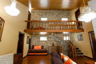 a living room with a staircase and a brick wall at Villa Albino Piscina climatizada in Ribas del Sil