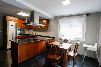 a kitchen with a table and chairs and a refrigerator at Villa Albino Piscina climatizada in Ribas del Sil