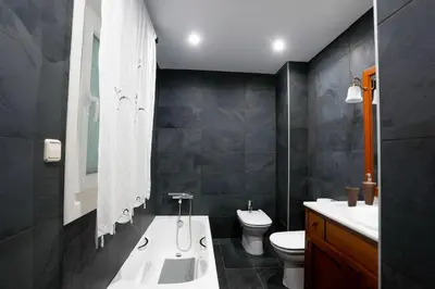 a bathroom with a tub and a toilet and a sink at Villa Albino Piscina climatizada in Ribas del Sil