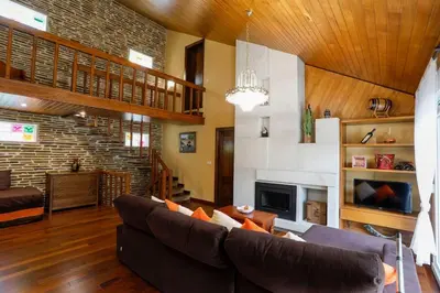 a living room with a couch and a fireplace at Villa Albino Piscina climatizada in Ribas del Sil