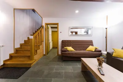 a living room with a couch and a staircase at Casa D'Abaixo in Arzúa