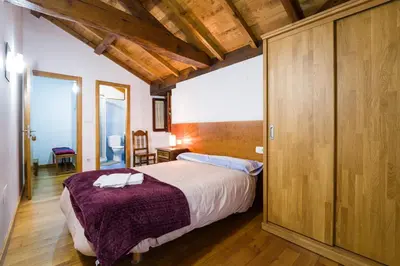 a bedroom with a large bed and wooden ceilings at Casa D'Abaixo in Arzúa
