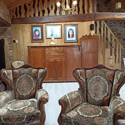 two chairs in a living room with pictures on the wall at Casa do Bico in Becerreá