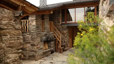 a stone house with a porch and a balcony at Casa do Bico in Becerreá