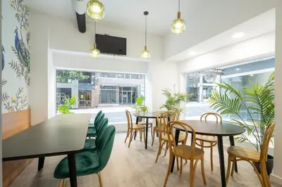 a dining room with tables and chairs and windows at Albergue Alda Pilgrim Ponferrada in Ponferrada